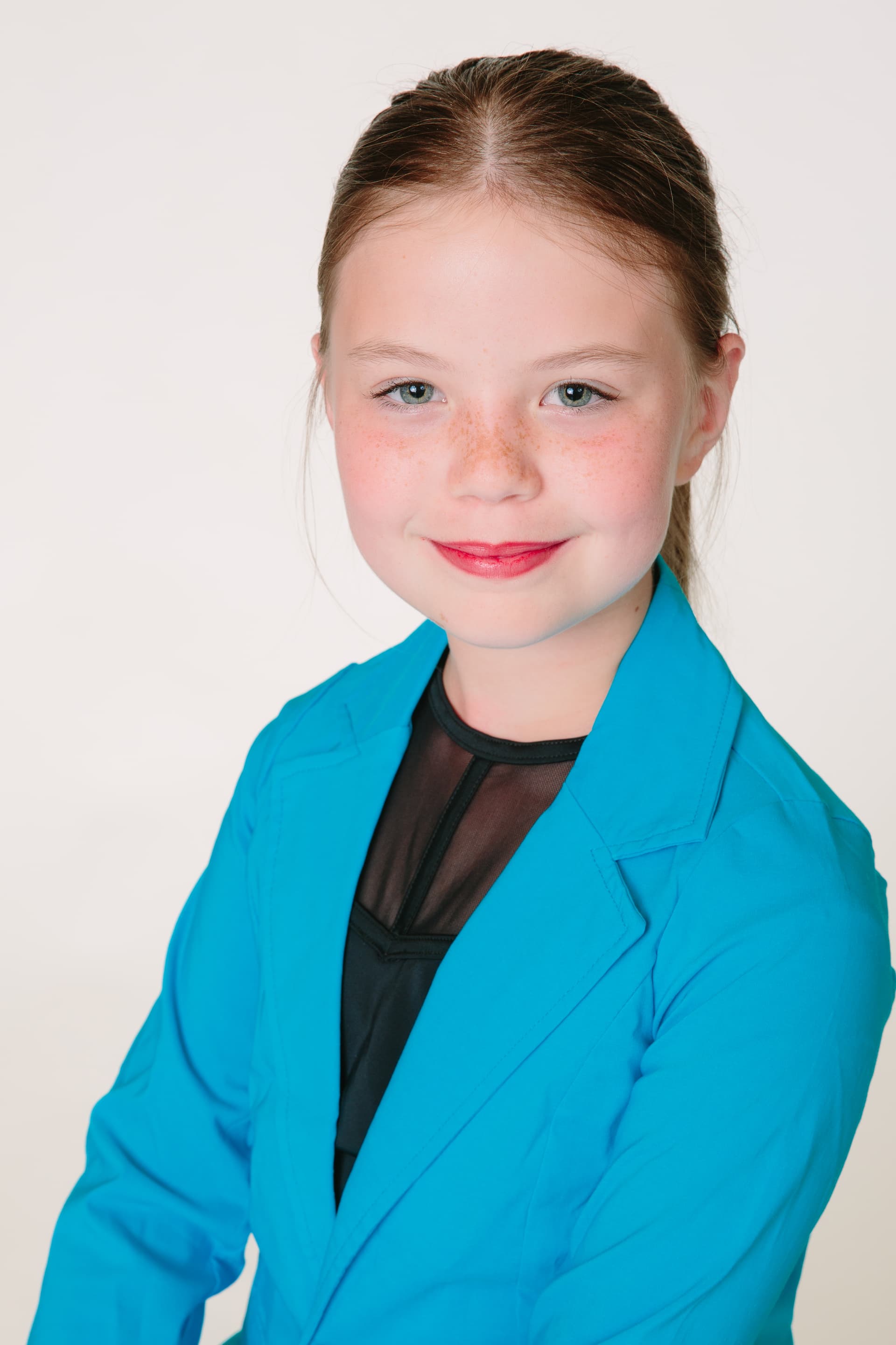 Reign smiling in a teal blazer